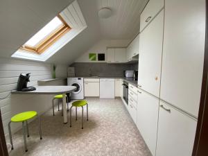 eine Küche mit weißen Schränken und grünen Stühlen in der Unterkunft Ferienwohnung Bad Säckingen ruhig und zentral in Bad Säckingen