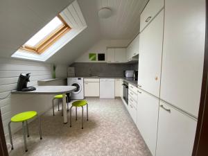 a kitchen with white cabinets and green stools at Ferienwohnung Bad Säckingen ruhig und zentral in Bad Säckingen