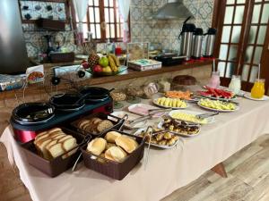 a table with many different types of food on it at Pousada Araucária Suítes in Campos do Jordão