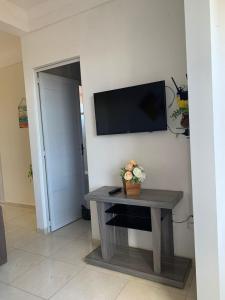 a room with a table and a television on a wall at Cantinho da Gê-"Sinta-se a vontade!"-Maragogi in Maragogi +19 photos