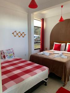 a bedroom with two beds and a window at Cantinho da Gê-"Sinta-se a vontade!"-Maragogi in Maragogi