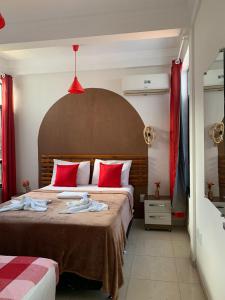 a bedroom with a large bed with red pillows at Cantinho da Gê-"Sinta-se a vontade!"-Maragogi in Maragogi