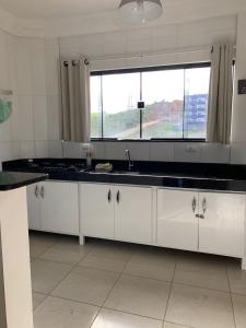a kitchen with a sink and a window at Cantinho da Gê-"Sinta-se a vontade!"-Maragogi in Maragogi