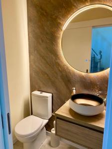 W łazience znajduje się umywalka, toaleta i lustro. w obiekcie Apartamento Cava do Viriato Deluxe w mieście Viseu