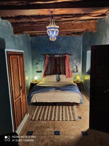 a bedroom with a bed and a chandelier at Riad La Rose Des Vents in Essaouira