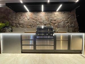 a kitchen with a stove and a stone wall at Luxury Suite by the pool in Eilat