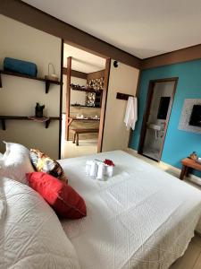 una camera da letto con un grande letto bianco con candele sopra di Um Lugar Agradável Em Meio a Natureza a Parati