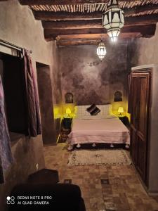 a bedroom with a bed and a chandelier at Riad La Rose Des Vents in Essaouira