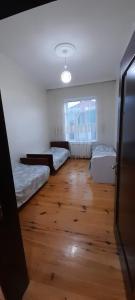 Habitación con 2 camas y suelo de madera. en Riverside villa, en Qusar