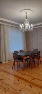 une salle à manger avec une table, des chaises et un lustre dans l'établissement Riverside villa, à Qusar
