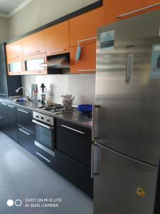 La cuisine est équipée d'un réfrigérateur et de placards en acier inoxydable. dans l'établissement Riverside villa, à Qusar