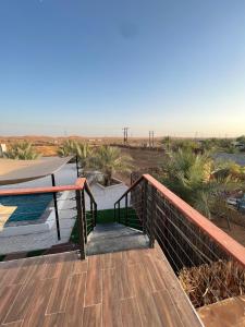 a wooden deck with a view of the desert at The Hidden Lodge in Al Ain