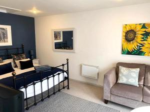 1 dormitorio con 1 cama, 1 silla y 1 sofá en Yew Tree View, en Marnhull