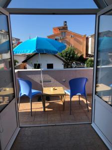 um pátio com uma mesa, 2 cadeiras e um guarda-sol em Taida em Donji Štoj