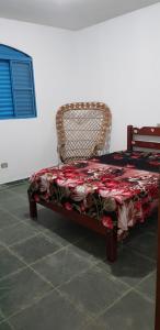 um quarto com uma cama e uma cadeira com uma colcha em Bela Chácara em Suzano