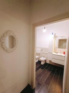 ein Badezimmer mit einem WC, einem Waschbecken und einem Spiegel in der Unterkunft Affittacamere Casa Marconi in Comacchio