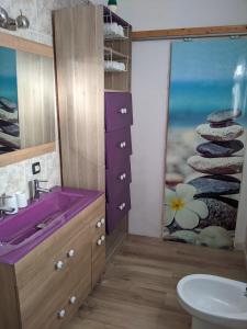 ein Badezimmer mit einem lila Waschbecken und einem Fenster in der Unterkunft La Casita del Sendero in La Guancha