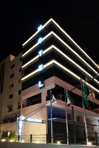 ein hohes Gebäude mit einer Flagge davor in der Unterkunft Diamond Hotel in Amman
