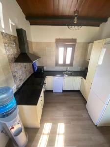 una pequeña cocina con fregadero y nevera. en Chalet cerca de la playa La Barrosa, en Chiclana de la Frontera