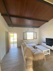 salon z długą kanapą i telewizorem w obiekcie Chalet cerca de la playa La Barrosa w mieście Chiclana de la Frontera
