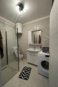 ein Badezimmer mit einem Waschbecken und einer Waschmaschine in der Unterkunft Villa Ante Škina in Sevid