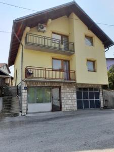 une maison jaune avec un balcon au-dessus dans l'établissement Pejovic, à Višegrad