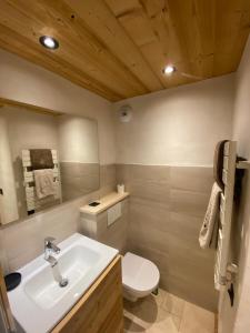 y baño con lavabo blanco y aseo. en Studio face aux pistes, en Praz-sur-Arly
