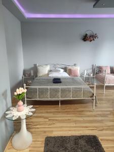 1 dormitorio con 1 cama grande y 1 mesa en Sára Apartman Nyíregyháza, en Nyíregyháza