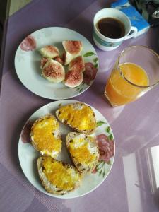 una mesa con dos platos de comida y un vaso de zumo en Bousounis Apartments, en Chrani