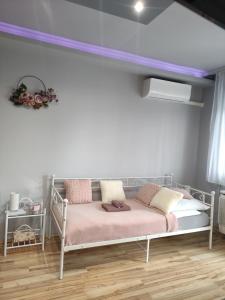 1 dormitorio con 1 cama con techo púrpura en Sára Apartman Nyíregyháza, en Nyíregyháza