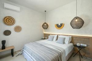 a bedroom with a bed and some pendant lights at Okeanis Mystique South in Ierápetra