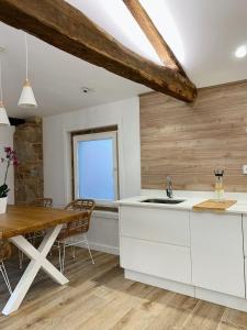 cocina con armarios blancos y mesa de madera en Celanova House, en Celanova