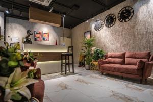 a living room with a couch and clocks on the wall at Diamond Hotel in Amman