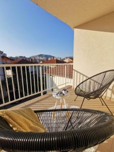 einen Balkon mit einem Sofa und einem Tisch auf dem Balkon in der Unterkunft Forest 88 apartment in Mostar
