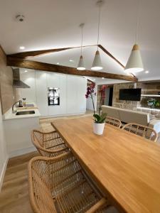 una cocina con una gran mesa de madera y sillas en Celanova House, en Celanova