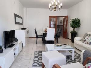 een woonkamer met een bank en een tv bij Blue Boat House - The Atlantic Breeze in Nazaré