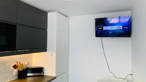 uma cozinha com uma televisão de ecrã plano na parede em OZEAN SUNSET HOUSE em Puerto de Santiago