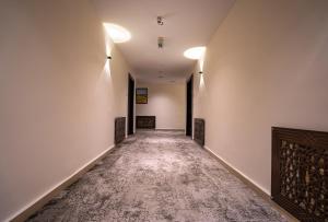 an empty hallway with white walls and a carpet at Diamond Hotel in Amman