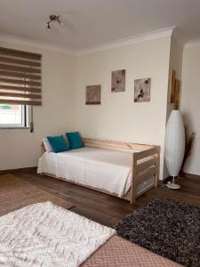 1 dormitorio con 1 cama con almohadas azules en Deluxe Studio com terraço e varanda privada - 'Casinha da Amoreira' Guesthouse, en Coímbra