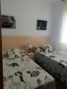 a bedroom with two beds and a tv on the wall at Apartamento Bella Carmen : para 6 personas in Cunit