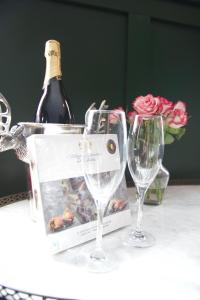 ウィットビーにあるMademoiselle's Boutique Holiday Accommodationのワイン1本とワイングラス2杯(テーブル上)
