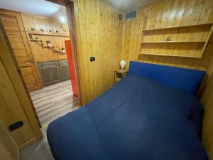 a bedroom with a blue bed and wooden walls at Chalet I Folletti in Abbadia San Salvatore