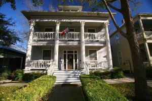 Una casa blanca con una bandera en la parte delantera. en Brackenridge House Bed and Breakfast, en San Antonio