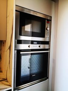 a microwave oven sitting inside of a wall at Superbe cosy T1 Bis Studio 40m2 indépendant en maison avec parking gratuit in Caluire-et-Cuire