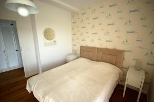 Un dormitorio con una cama y una pared con botes. en Błękitny domek, en Darłowo