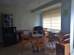 ein Klassenzimmer mit Tischen und Stühlen und ein Zimmer mit einem Fenster in der Unterkunft Pension San Roque in Lugo