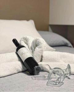 a bottle of wine and towels on a bed at OAZA MIRA Mobile Houses - Camp Baško Polje #BestOffer in Baška Voda