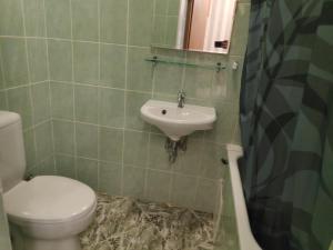 La salle de bains est pourvue de toilettes et d'un lavabo. dans l'établissement Mini Chisinau Hotel, à Chişinău