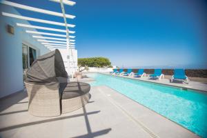 a swimming pool with chairs next to a building at Casa Conil with a private 25 meter heated pool in Conil