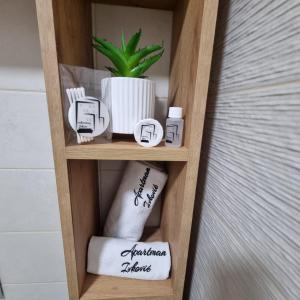 a wooden shelf with towels and a potted plant at Apartman Ivkovic in Sremska Mitrovica